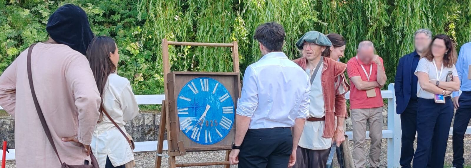 Un participant à l'orientescape 1587 est face à la machine à 
    remonter le temps d'AniméO sous l'oeil de ses collègues et entouré des acteurs.
